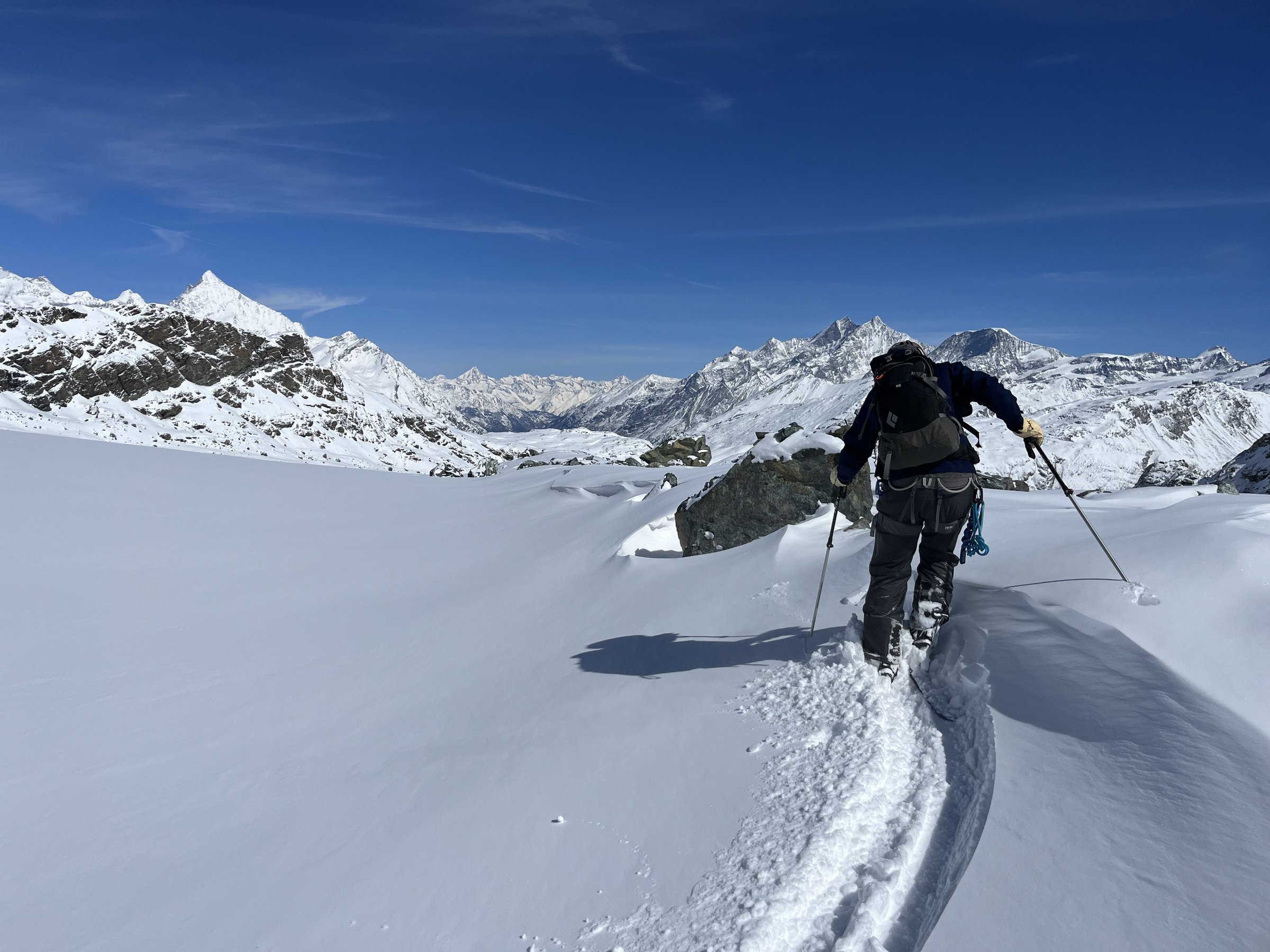 Ski touring through pristine alpine powder with mountain peaks